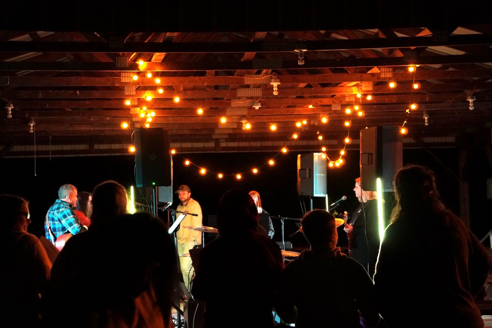 The crowd worshipping under string lights